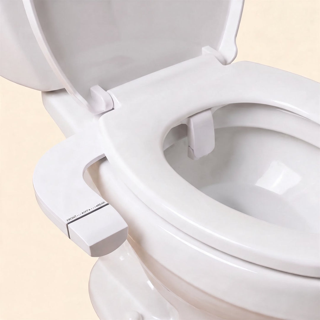 Le bidet TUPUDUKU en place sous la lunette d’un WC classique, vu de près, avec sa molette FRONT, OFF, REAR sur le côté